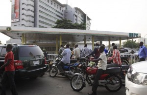 FILE - In this Wednesday Jan. 11, 2012, file photo, people line up to buy fuel at a government petrol station on the third day of nation wide strike following the removal of a fuel subsidy in Lagos, Nigeria. Nigerian airlines grounded flights Saturday, May 23, 2015, as a months-long fuel shortage worsened, aggravated by a strike disrupting fuel deliveries in Africa's biggest oil producer. Vehicles also were grounded. Normally bustling roads in Lagos, a metropolis of 20 million, were half-empty and gas stations closed Saturday. (AP Photo/Sunday Alamba, file) 